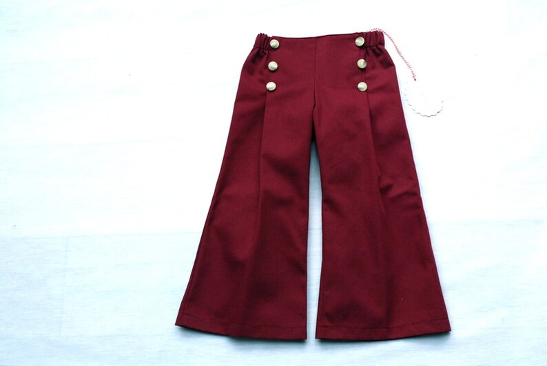 Pantaloni per bambini in alambicco marittimo, pantaloni da marinaio Fiete in rosso scuro-bordeaux, con gamba larga, pettorale da marinaio destro e sinistro con bottoni. immagine 2