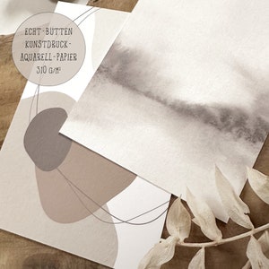 May include: Two pieces of watercolor paper with abstract designs. One piece features a gray and brown watercolor wash, while the other has a brown and beige abstract design with thin black lines. The text "ECHT - B&Uuml;TTEN KUNSTDRUCK - AQUARELL - PAPIER 310 G/M&sup2;" is printed on the top of the paper with the abstract design.