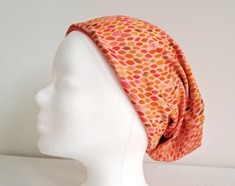 Bonnet réversible à motif fleuri orange et uni rouge corail