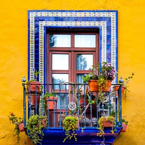 Puebla, México, Ventana de marco azul en una pared amarilla con flores ...