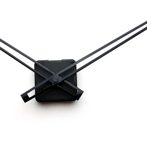 May include: Black clock hands with a square black clock mechanism. The hands are crossed in the center of the mechanism.