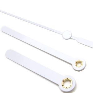 Op de afbeelding: Drie witte wijzers met gouden accenten. De langste wijzer is de uurwijzer, de middelste wijzer is de minutenwijzer en de kortste wijzer is de secondewijzer.