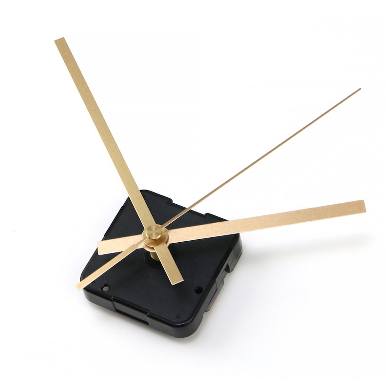 May include: A clock movement with a black square base and gold-colored hands. The hands include an hour hand, a minute hand, and a second hand. The hands are thin and rectangular, and the base has mounting holes.