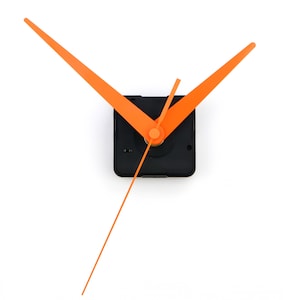 Puede incluir: Mecanismo de reloj con manecillas de color naranja brillante y un segundero a juego. Las manecillas son largas y delgadas, con un diseño moderno. El movimiento del reloj está alojado en una caja cuadrada negra, y las manecillas están centradas.