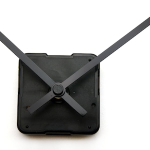 May include: Black clock hands with a black plastic clock movement. The hands are in a cross position.