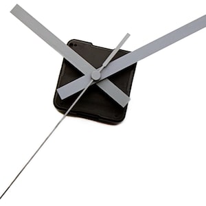 May include: A set of clock hands with a black clock movement. The hands are silver and the hour hand is long and thin. The minute and second hands are shorter and wider.