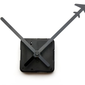 May include: Black clock hands with a square clock mechanism. The minute hand is shaped like an airplane.