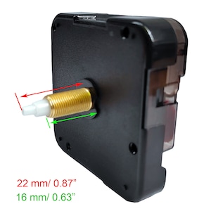 Puede incluir: Primer plano de un movimiento de reloj negro con un eje de color dorado. El eje mide 22 mm / 0,87" de largo y 16 mm / 0,63" de di&aacute;metro.