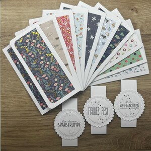 Könnte beinhalten: Eine Sammlung dekorativer Geschenkanhänger und Karten mit verschiedenen Mustern. Die Karten zeigen Designs wie Blumen, Schneeflocken und Weihnachtsmotive. Die Geschenkanhänger haben einen gezackten Rand und den Text "Frohes Fest" und "Frohe Weihnachten".