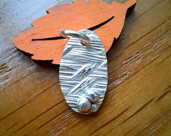 Oval pendant made of 999 recycled silver with great texture and small fine silver nuggets