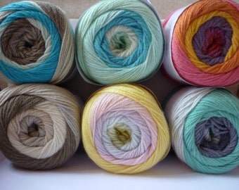 Könnte beinhalten: Sechs Knäuel Garn in verschiedenen Farben, darunter Türkis, Grün, Rosa, Gelb, Beige und Grau. Jedes Knäuel hat ein mehrfarbiges gestreiftes Muster.
