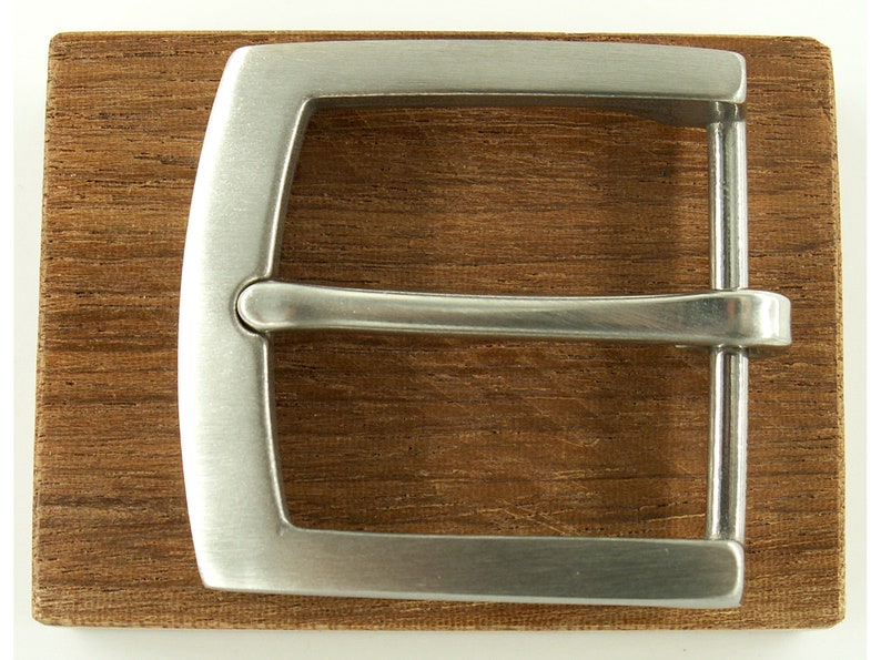 May include: A silver metal belt buckle with a smooth, polished finish. The buckle is rectangular with rounded corners and has a simple, classic design.