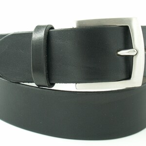 May include: A black leather belt with a silver buckle. The belt is folded in half and the buckle is visible.