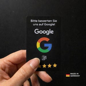 Puede incluir: Tarjeta negra con el logotipo de Google en rojo, amarillo, verde y azul. La tarjeta tiene el texto "Bitte bewerten Sie uns auf Google!" y "Google". También tiene un símbolo NFC y cinco estrellas doradas. Hecho en Alemania.