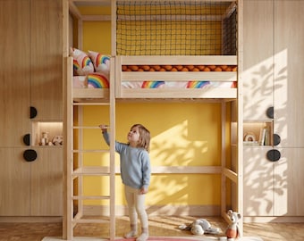 Puede incluir: Una cama alta de madera con una escalera, una red de seguridad negra y ropa de cama con temática de arcoíris. La cama está en una habitación con armarios de madera, una pared amarilla y una alfombra de arcoíris. Un niño pequeño está de pie cerca de la escalera.