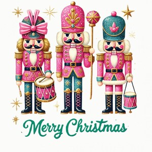 Op de afbeelding: Drie decoratieve notenkrakers in roze, teal en goud, met zwarte laarzen en snorren. Eén houdt een trommel vast, een ander een staf en de derde een kleine trommel. De woorden "Merry Christmas" staan eronder in het groen.