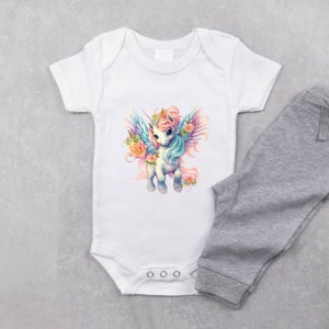 May include: White baby onesie with a colorful unicorn with wings and flowers. The onesie has three white snaps at the bottom.
