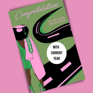 Puede incluir: Tarjeta de felicitación 2022 con un camino verde y negro y una mujer con una toga de graduación rosa y un vestido verde caminando por el camino. El texto "With Current Year" está en un círculo en el camino.