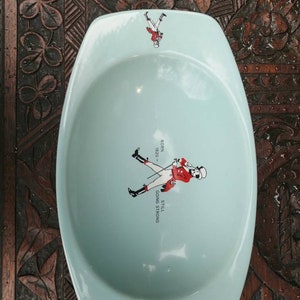 May include: A light blue ceramic ashtray with a walking man graphic and the text "Still Going Strong - 1920 -  "