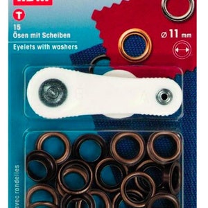 May include: A pack of 15 bronze eyelet sets with washers, each measuring 11 mm in diameter. The pack includes a tool for installing the eyelets. The text on the pack reads "15 Ösen mit Scheiben Eyelets with washers".