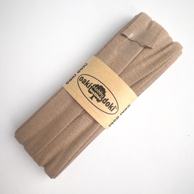 Nahaufnahme eines 5m langen Jersey-Schrägbandes aus elastischem Stoff in beige.