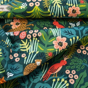 May include: A dark green fabric featuring a repeating pattern of orange birds, spotted leopards, and monkeys amidst pink flowers, berries, and various green leaves. A small rectangular label in the top left corner displays the text H&uuml;ndisch-Design.