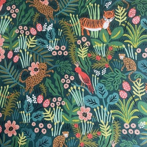 May include: A dark green fabric featuring a repeating pattern of orange tigers, spotted leopards, monkeys, and pink birds nestled among stylized foliage, ferns, and clusters of small pink and white berries throughout the dense jungle scene.