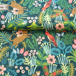 May include: A dark green fabric featuring a repeating pattern of orange leopards, tigers, and birds amidst pink flowers, white berries, and various green tropical leaves. A small rectangular label with the text H&auml;ndisch-Design is visible.