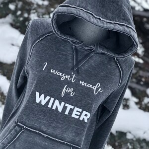May include: A gray hooded sweatshirt with the text "I wasn't made for WINTER" printed in white on the front.