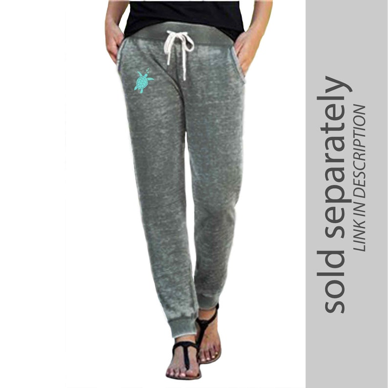Pu&ograve; includere: Pantaloni della tuta grigi con una grafica di tartaruga marina turchese sulla gamba sinistra. I pantaloni della tuta hanno una vita con coulisse e un fondo a polsino.