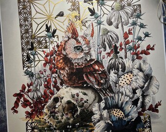 May include: A detailed illustration of an owl perched on a skull surrounded by flowers and leaves. The owl has a large, bright eye and is rendered in shades of brown, red, and white. The skull is white with a green moss-like growth. The flowers are in shades of white, blue, and red. The background is a gold geometric pattern.