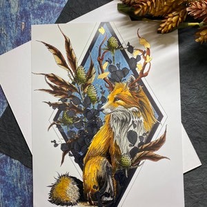May include: A stylized illustration of a fox with antlers, surrounded by gold and brown foliage. The fox is sitting in a diamond-shaped frame with a blue background.