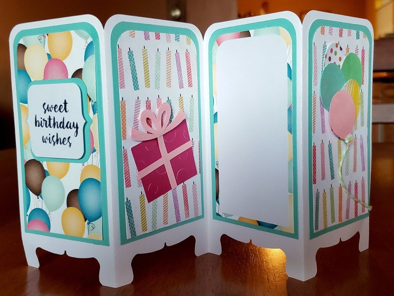 May include: A three-panel card with a teal border and a white background. The front panel has a balloon pattern and the text "sweet birthday wishes". The middle panel has a pattern of colorful candles and a pink gift box with a bow. The back panel has a blank white space.