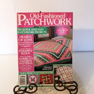 May include: A vintage "Old-Fashioned Patchwork" magazine from Spring 1988, displayed on a decorative metal stand. The cover features a pink and green quilt, with text highlighting quick and easy patchwork projects and applique techniques.