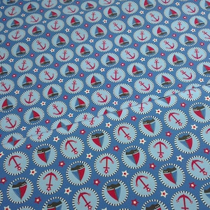 Könnte beinhalten: Blauer Stoff mit einem sich wiederholenden Muster aus roten, weißen und blauen Ankern, Segelbooten und Sternen. Der Stoff ist perfekt für Bastelprojekte.