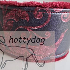 Könnte beinhalten: Ein breites Halsband mit einer schwarzen Kunstlederoberfläche und einem dunkelroten, geschwungenen Damastmuster. Die Innenseite ist mit einem weichen, tiefroten Plüschstoff gefüttert. Der Text hottydog ist vorne aufgedruckt, ergänzt durch eine Strichzeichnung eines Hundes.