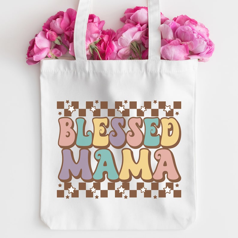 May include: White tote bag with brown and white checkered pattern and stars. The text "Blessed Mama" is in colorful retro font.