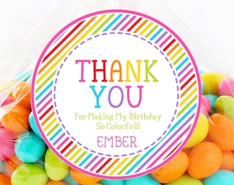 May include: A clear cellophane bag filled with colorful candies, tied with a pink polka dot ribbon. A round sticker on the bag reads "THANK YOU" in rainbow colors, with the text "For Making My Birthday So Colorful!" and the name "EMBER".