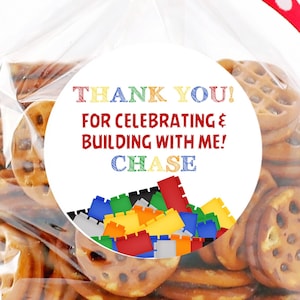 May include: A round sticker with a white background and colourful text that says "Thank You! For Celebrating & Building With Me! Chase". The sticker has a colourful image of Lego blocks around the text.