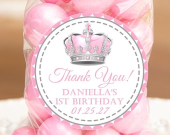 May include: A clear plastic favor bag filled with pink candy and a round sticker with a silver crown, pink and gray polka dots, and the text "Thank You!  Daniella's 1st Birthday 01.25.27".