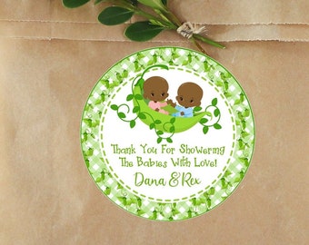 May include: Round green and white patterned sticker with two brown babies in a green pea pod. The sticker says "Thank You For Showering The Babies With Love! Dana & Rex".