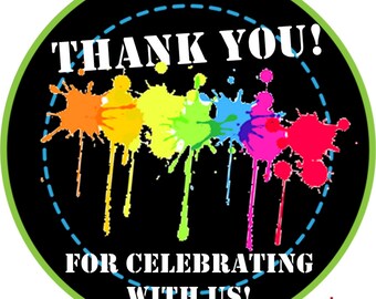 May include: Round sticker with a black background and a white border. The sticker says "Thank You!" in white text and "For Celebrating With Us!" in white text. The sticker has a rainbow paint splatter design.