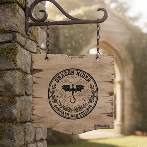 May include: A distressed wooden sign displaying "DRAGON RIDER BASGIATH WAR COLLEGE" within a circular emblem featuring a dragon. The sign is suspended by chains from a decorative metal bracket on a stone wall.