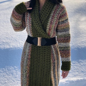 May include: A long, green and multi-colored striped cardigan with a wide collar and a black belt.