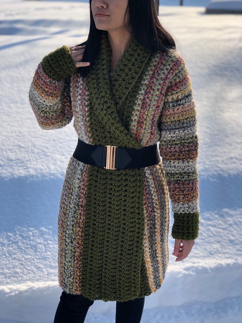 May include: A long, green and multi-colored striped cardigan with a wide collar and a black belt.