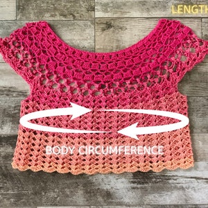 Op de afbeelding: Een roze en oranje gehaakt topje met korte mouwen. Het topje heeft een gegolfde zoom en een haakpatroon. De tekst "BODY CIRCUMFERENCE" en "LENGTH" staat op de afbeelding.