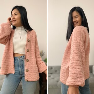 May include: A pink crocheted cardigan with a button closure. The cardigan has a relaxed fit and long sleeves.