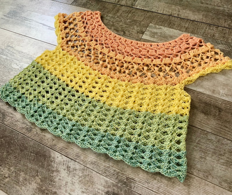 Op de afbeelding: Een veelkleurig gehaakt topje met een regenboogpatroon. Het topje is gemaakt van zacht, lichtgewicht garen en heeft een losse, zwierige pasvorm.