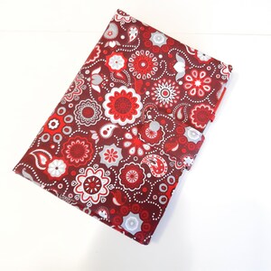 Könnte beinhalten: Ein roter und weißer Paisley-Stoffbezug für ein Notizbuch. Der Bezug hat eine Klappe, die mit einem Knopf geschlossen wird.