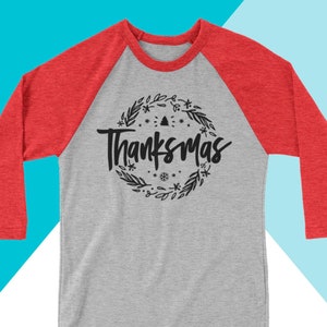 May include: A gray and red baseball tee shirt with a black graphic design that says "Thanksmas" in a wreath. The design is property of North Owl Apparel and is not for sale or personal use.